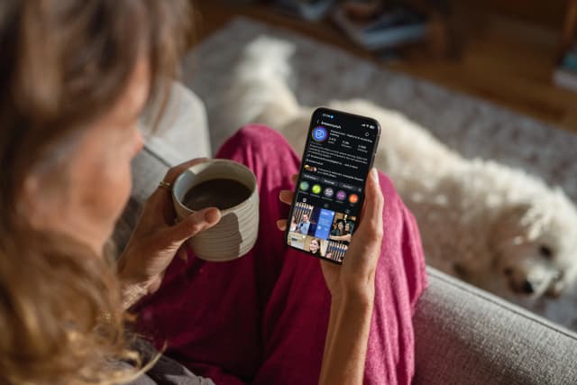 Person browsing the Knowcrunch Instagram profile on a smartphone while relaxing at home.