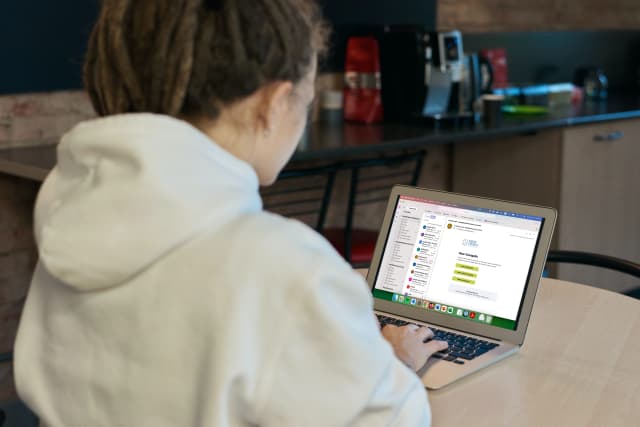 Person working on an email marketing campaign using a laptop in a casual workspace.