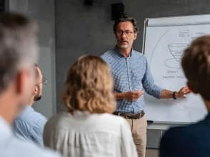 Instructor explaining a digital marketing funnel strategy to a group using a whiteboard.